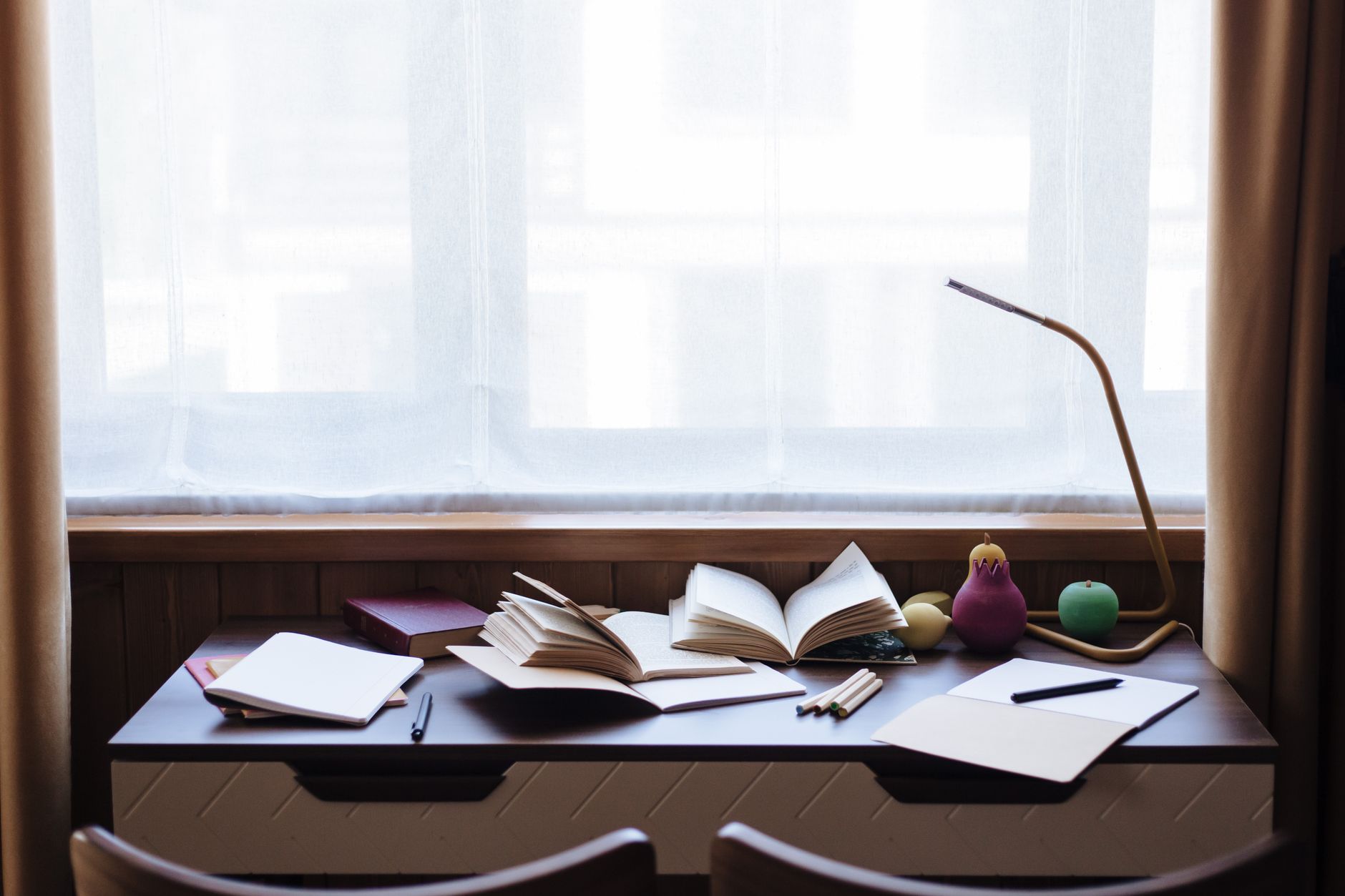 窓辺の机で資料を読む静かな作業風景